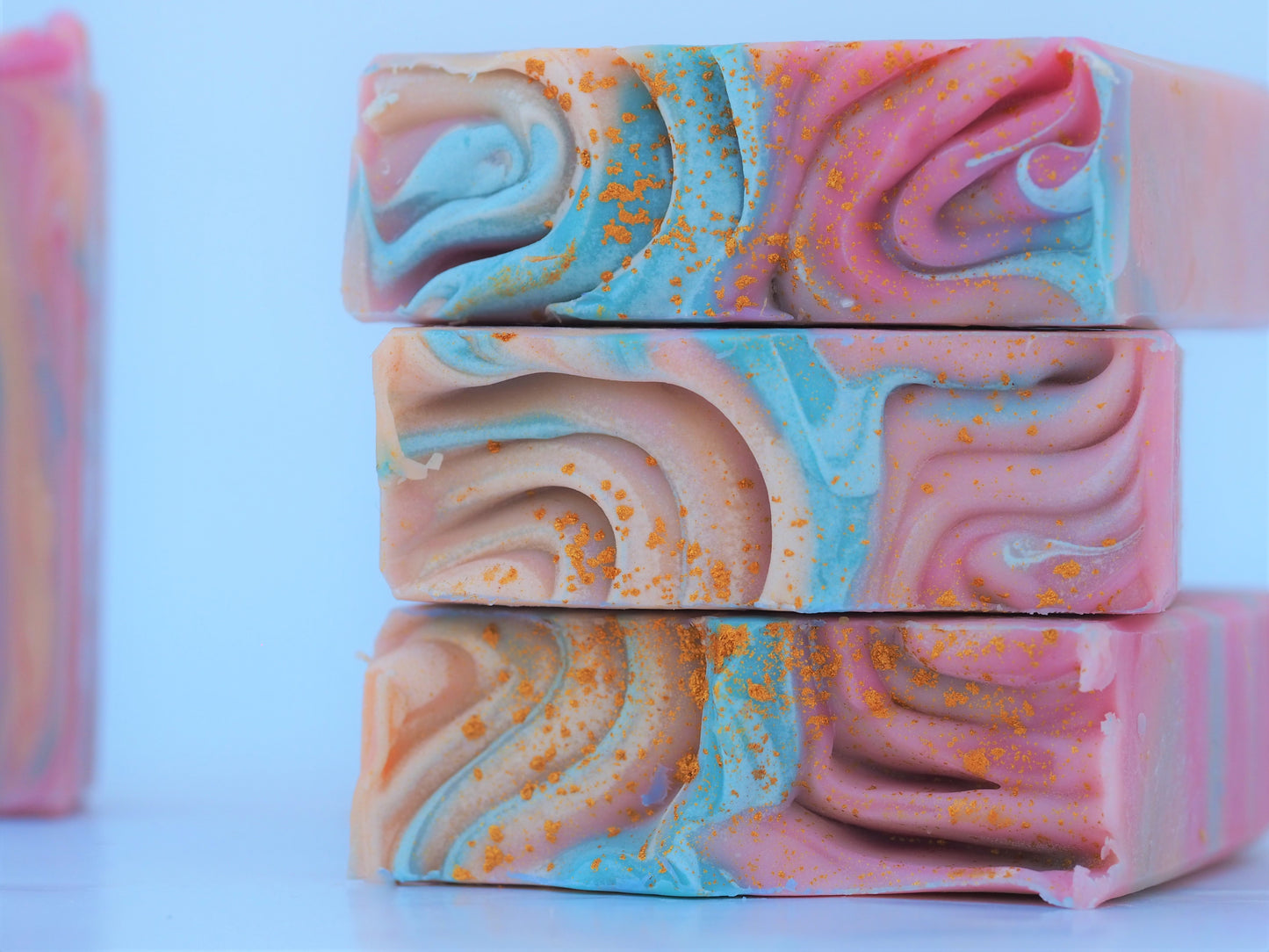 Bohemian Handmade Artisan Soap Bar with swirls of pink, apricot, turquoise, and golden mica, finished with a rainbow top. Vegan-friendly and perfect for sensitive skin. Olive oil, shea butter soap.