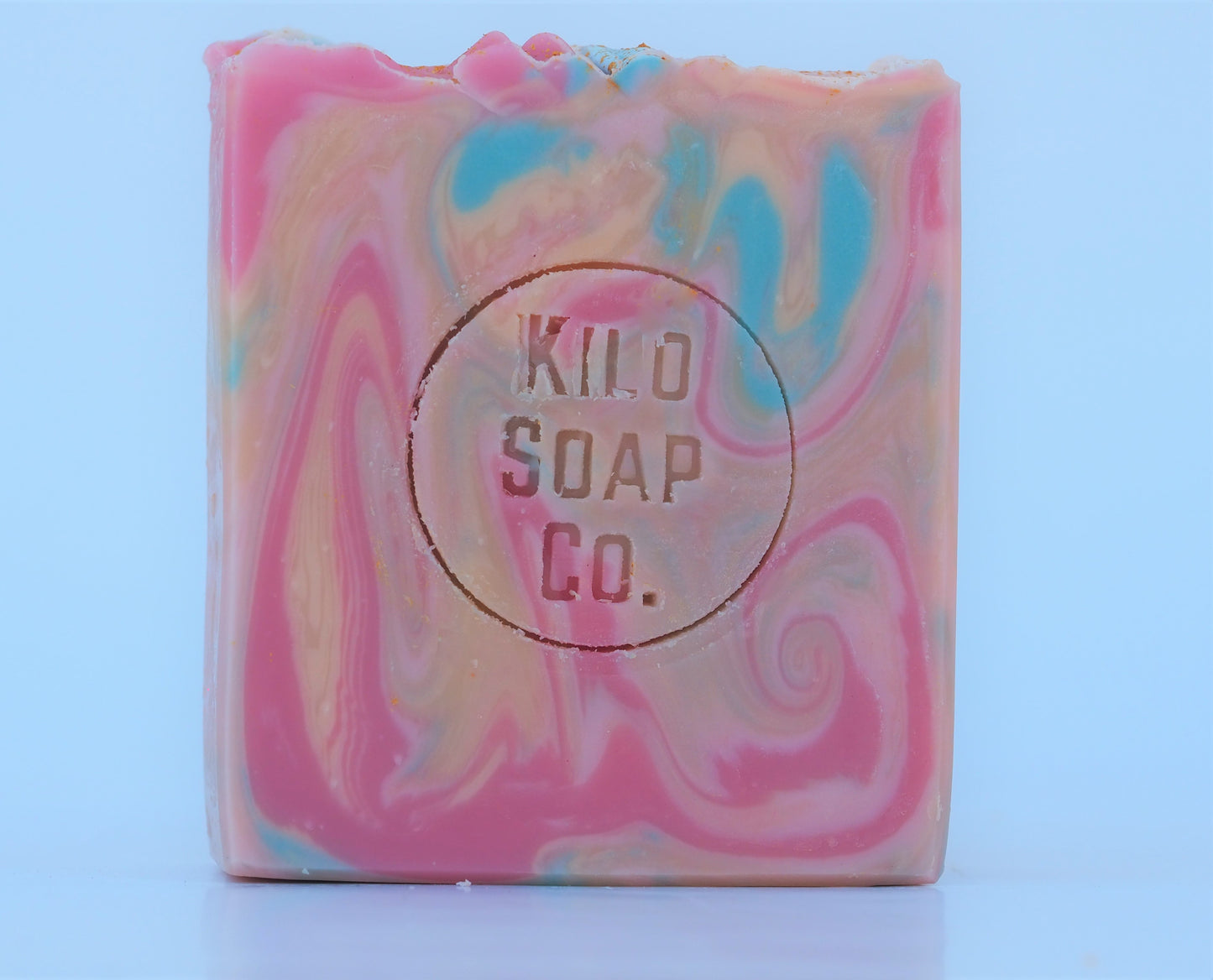 Bohemian Handmade Artisan Soap Bar with swirls of pink, apricot, turquoise, and golden mica, finished with a rainbow top. Vegan-friendly and perfect for sensitive skin. Olive oil, shea butter soap.
