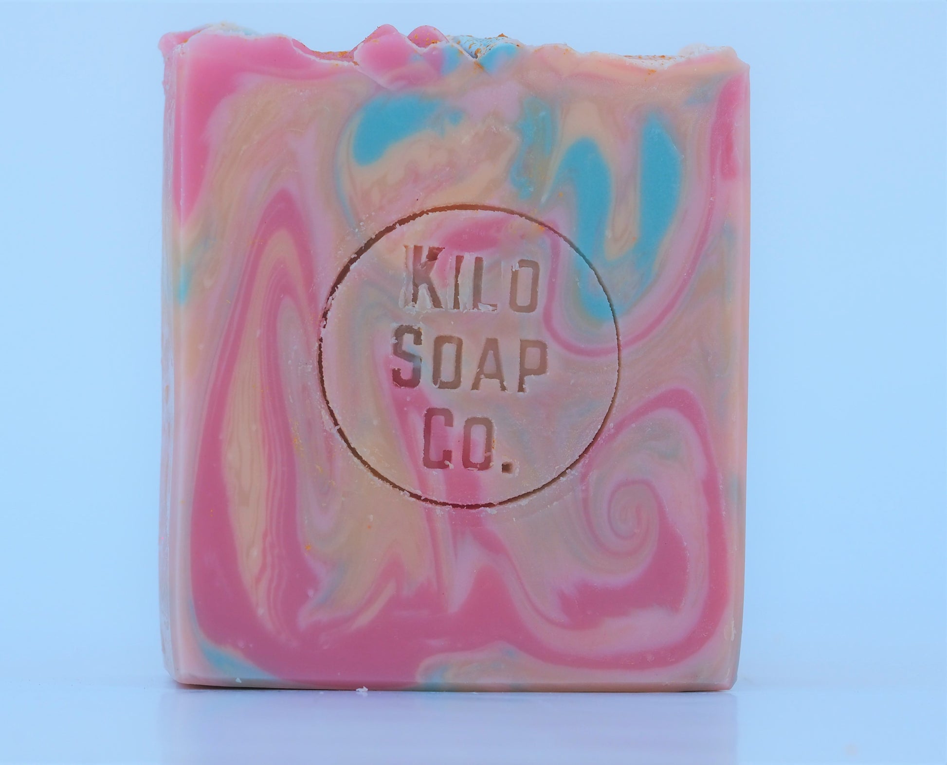 Bohemian Handmade Artisan Soap Bar with swirls of pink, apricot, turquoise, and golden mica, finished with a rainbow top. Vegan-friendly and perfect for sensitive skin. Olive oil, shea butter soap.