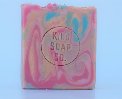 Bohemian Handmade Artisan Soap Bar with swirls of pink, apricot, turquoise, and golden mica, finished with a rainbow top. Vegan-friendly and perfect for sensitive skin. Olive oil, shea butter soap.