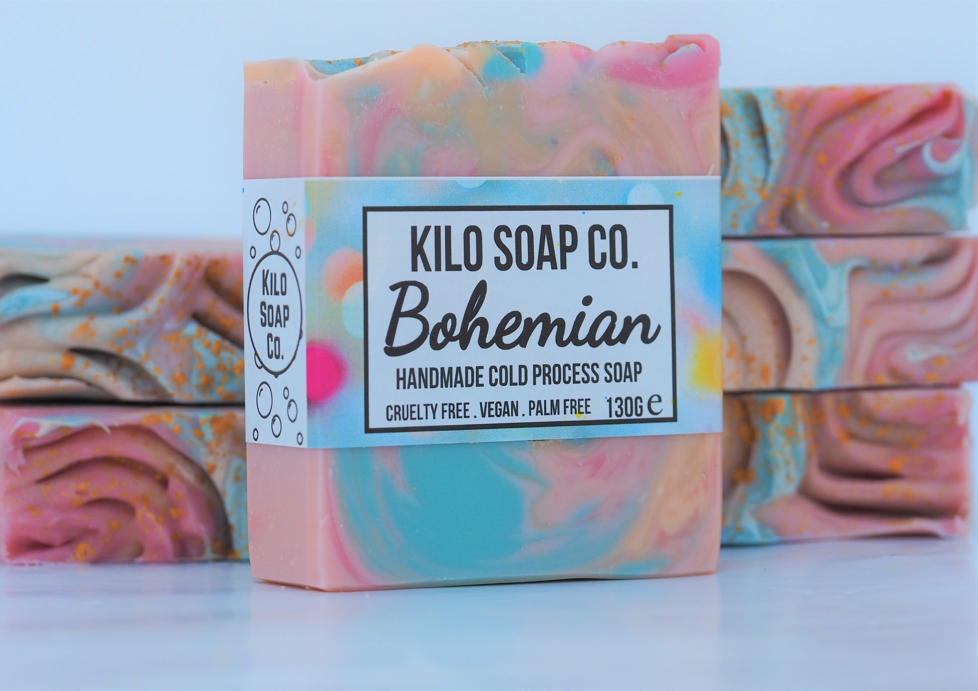 Bohemian Handmade Artisan Soap Bar with swirls of pink, apricot, turquoise, and golden mica, finished with a rainbow top. Vegan-friendly and perfect for sensitive skin. Olive oil, shea butter soap.
