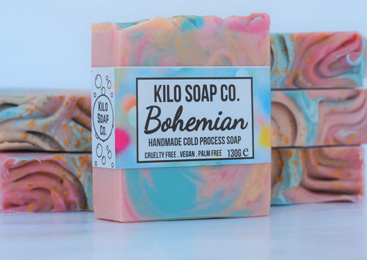 Bohemian Handmade Artisan Soap Bar with swirls of pink, apricot, turquoise, and golden mica, finished with a rainbow top. Vegan-friendly and perfect for sensitive skin. Olive oil, shea butter soap.