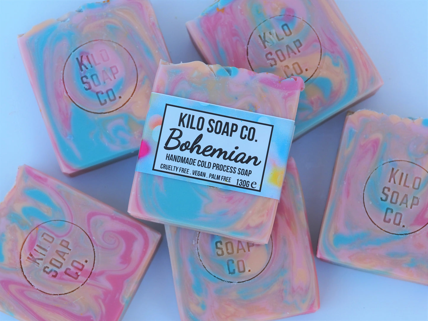 Bohemian Handmade Artisan Soap Bar with swirls of pink, apricot, turquoise, and golden mica, finished with a rainbow top. Vegan-friendly and perfect for sensitive skin. Olive oil, shea butter soap.